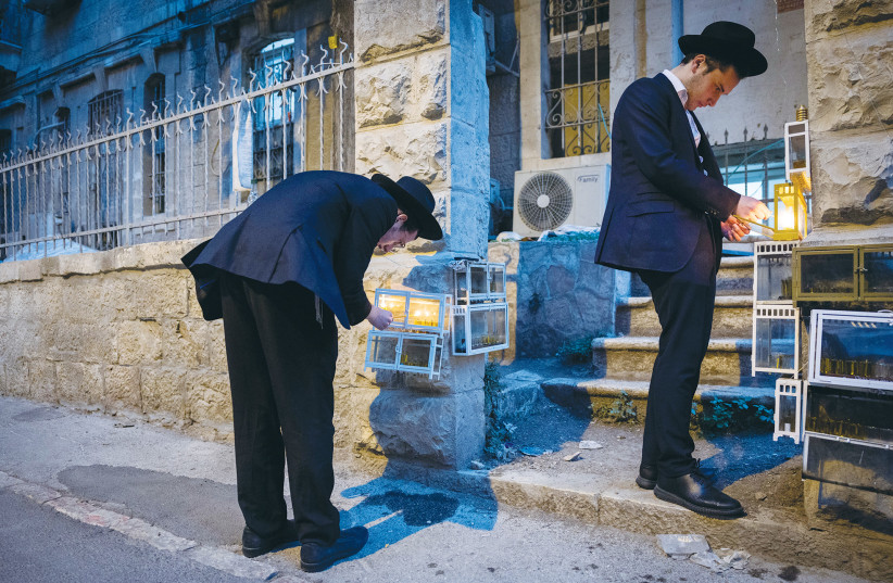  HANUKKAH CANDLES are lit outdoors, in Jerusalem, last December. (photo credit: YONATAN SINDEL/FLASH90)