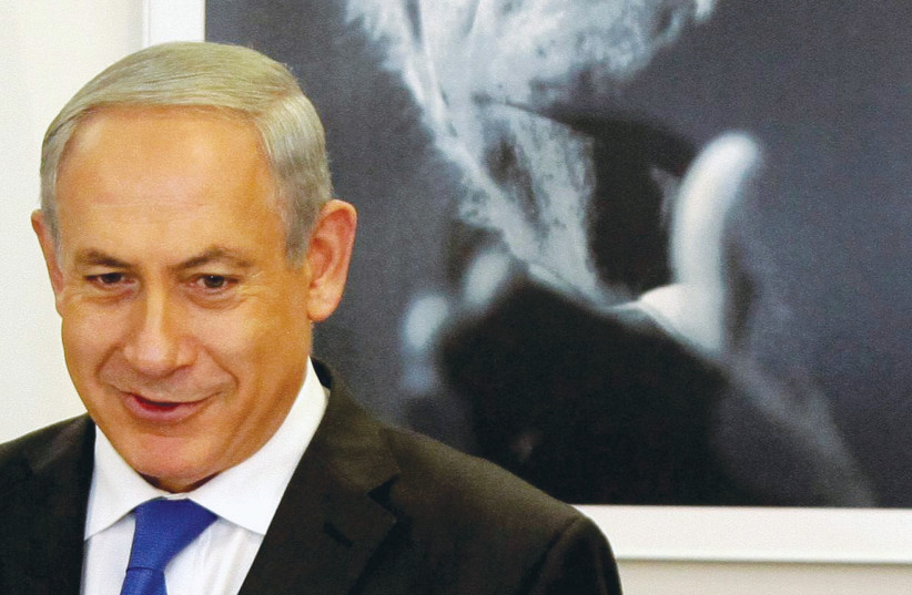  PRIME MINISTER Benjamin Netanyahu stands in front of a portrait of first prime minister David Ben-Gurion. (photo credit: EDI ISRAEL/FLASH90)