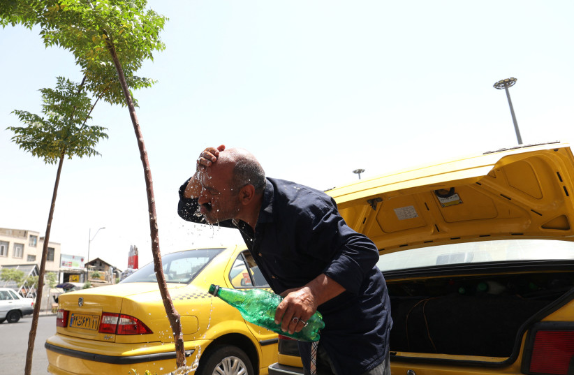  An Iranian taxi driver splashes water on himself to cool down during the heat surge in Tehran, Iran August 2, 2023. (photo credit: MAJID ASGARIPOUR/WANA (WEST ASIA NEWS AGENCY) VIA REUTERS)