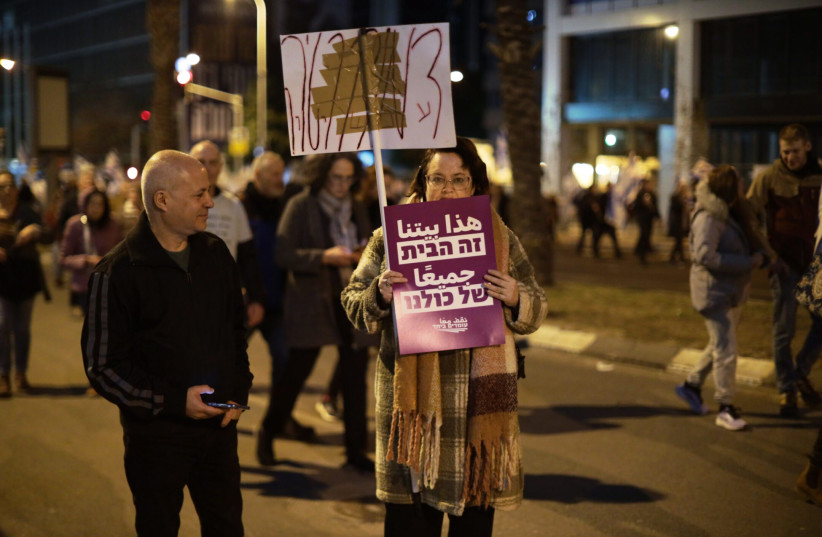  A lone protester advocating in Hebrew and Arabic for coexistence participates in a protest against planned changes to Israel's judicial system, Tel Aviv, Feb. 11, 2023.  (photo credit: Saeed Qaq/Anadolu Agency via Getty Images)