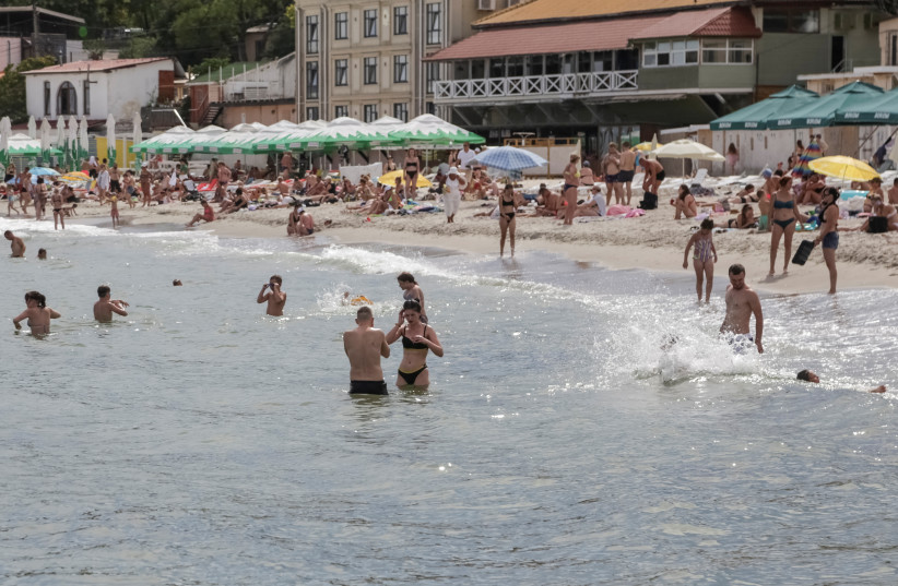  People relax at a Black Sea beach that was reopened after being closed down last year following sea mines laid around the ports of Odesa and Mykolaiv by Russia and Ukraine, amid Russia's attack on Ukraine, in Odesa, Ukraine August 10, 2023. (photo credit: REUTERS/Serhii Smolientsev)