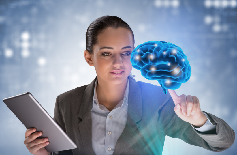  A woman is seen looking an artificial projection of a brain in this illustrative image meant to represent artificial intelligence (AI). (photo credit: INGIMAGE)