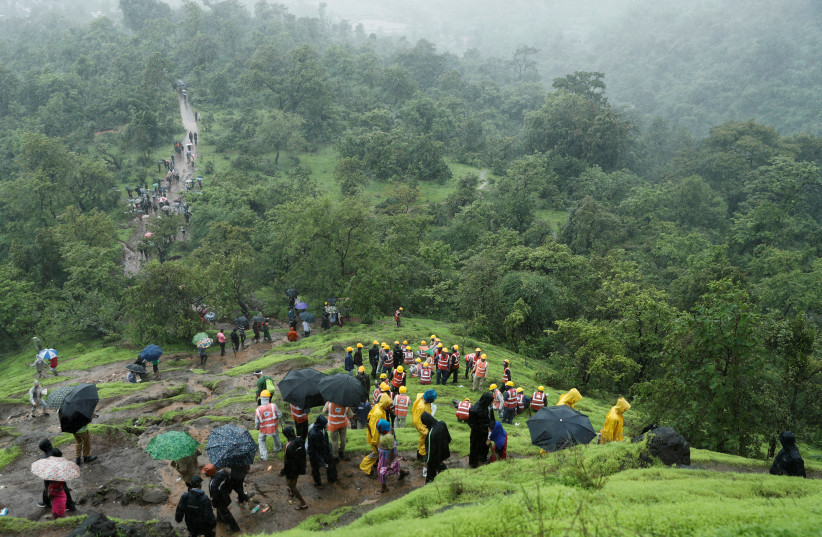  National Disaster Response Force (NDRF) personnel and other volunteers climb up a mountain to reach the site of a landslide at a village in Raigad, in the western state of Maharashtra, India July 20, 2023 (photo credit: REUTERS/FRANCIS MASCARENHAS)