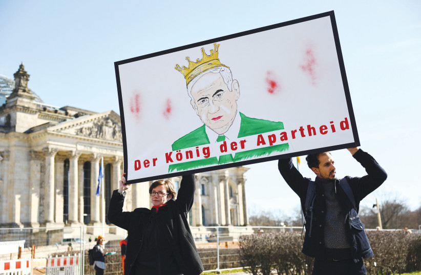  DEMONSTRATORS IN Berlin hold a poster with a drawing of Prime Minister Benjamin Netanyahu that reads ‘The King of Apartheid,’ while protesting against Netanyahu’s visit to Germany earlier this year.  (photo credit: Christian Mang/Reuters)