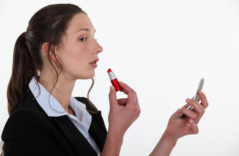 Woman applying lipstick (illustrative). (photo credit: INGIMAGE)