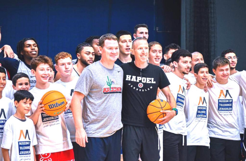  ARIZONA COACH Tommy Lloyd (center left) and Tamir Goodman (center right) pose with youth basketball players in their training session in Jerusalem this week. (photo credit: YEHUDA HALICKMAN)