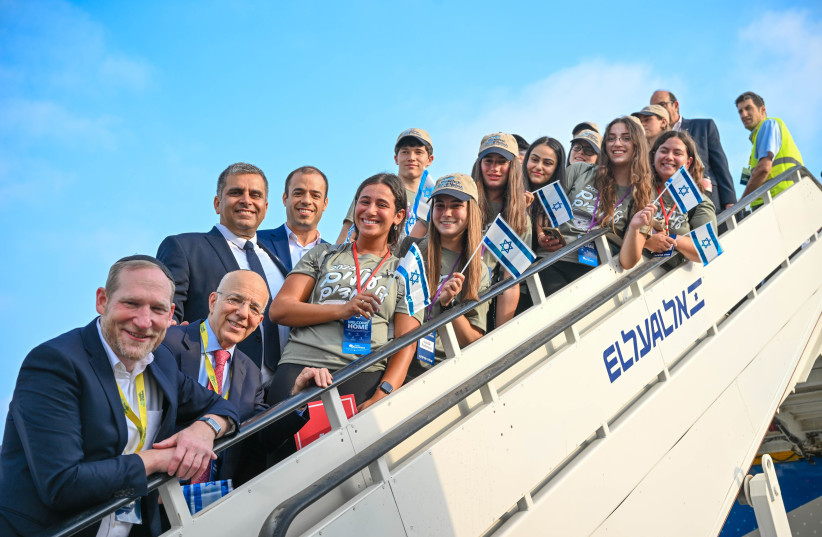  Olim on the 64th Nefesh B’Nefesh charter flight pose with the organization’s co-founders Rabbi Yehoshua Fass and Tony Gelbart; Aliyah and Integration Minister Ofir Sofer; and ministry Director-General Avichai Kahana.  (photo credit: SHAHAR AZRAN, YONIT SCHILLER)