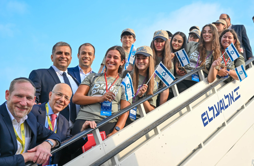 Olim on the 64th Nefesh B’Nefesh charter flight pose with organization’s Co-founders Rabbi Yehoshua Fass and Tony Gelbart; Minister of Aliyah and Integration, Ofir Sofer; and Director-General of the Ministry of Aliyah and Integration, Avichai Kahana.  (photo credit: SHACHAR AZRAN, YONIT SCHILLER)