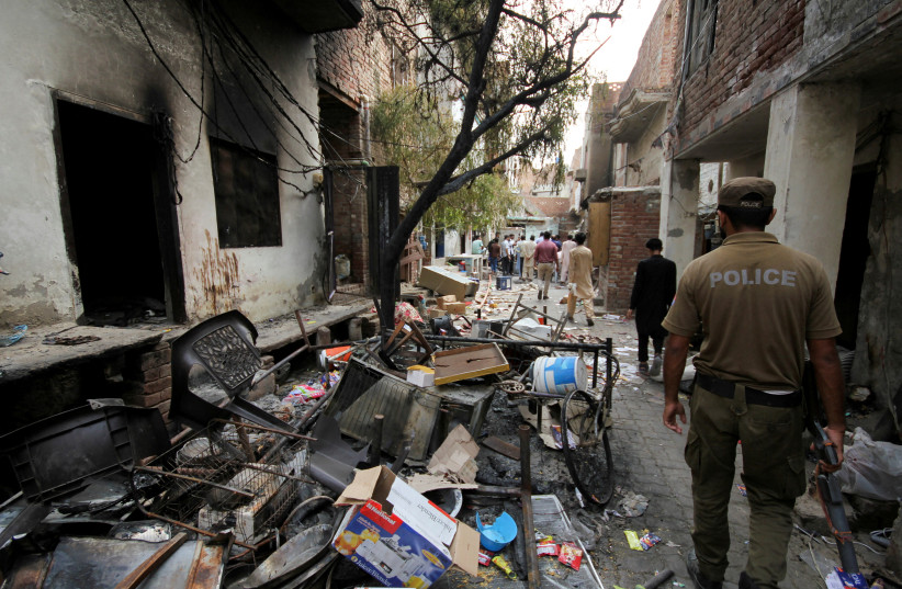  A police officer walks past the belongings of the residents along a street in a Christian neighbourhood, a day after the church buildings and houses were vandalised by protesters in Jaranwala, Pakistan August 17, 2023 (photo credit: REUTERS/MUHAMMAD TAHIR)