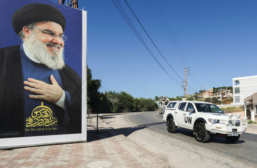  A UNIFIL VEHICLE drives near a picture showing Hezbollah leader Hassan Nasrallah, in Adaisseh village, near the Lebanese-Israeli border, last month. (photo credit: AZIZ TAHER/REUTERS)