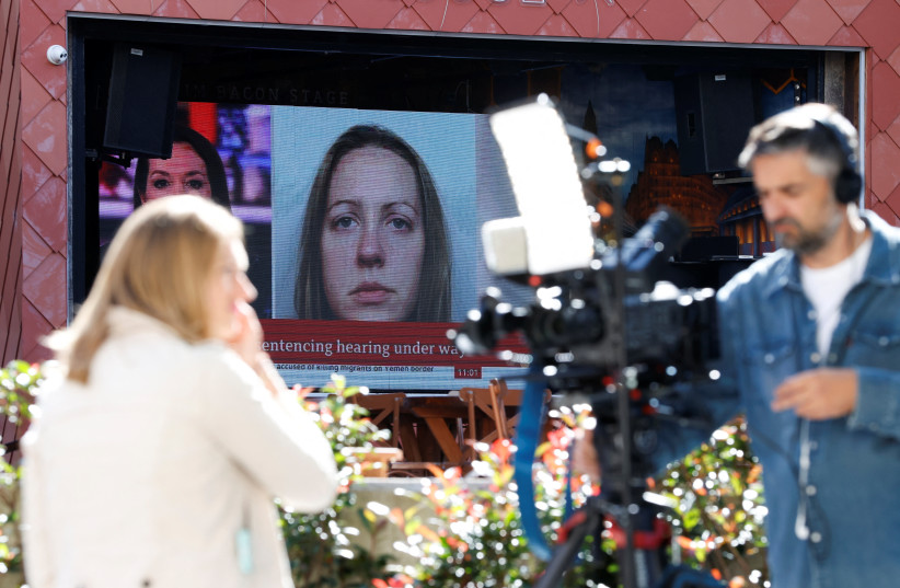 Members of the media work near a large screen showing a picture of convicted hospital nurse Lucy Letby, ahead of her sentencing, outside the Manchester Crown Court, in Manchester, Britain, August 21, 2023. (photo credit: PHIL NOBLE/REUTERS)