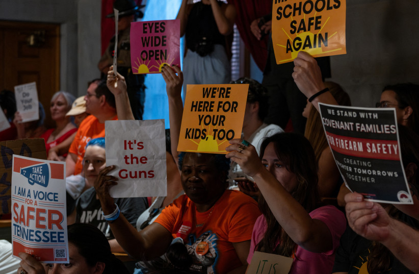  Supporters of gun reform hold signs in the gallery seating in the House Chamber of the Tennessee State Capitol building during a special session on public safety to discuss gun violence in the wake of the Covenant School shooting in Nashville, Tennessee, U.S., August 21, 2023. (photo credit: REUTERS/SETH HERALD)