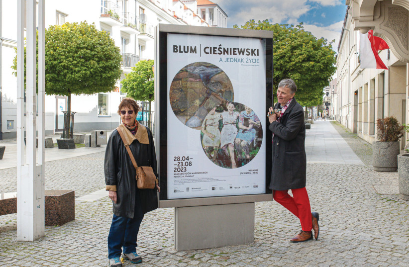  ARTIST AVIVA BLUM and Polish painter Wojciech  Ciesniewski flank a street poster of their exhibition in Plock.  (photo credit: Fundacja Wojciecha Cieśniewskiego)