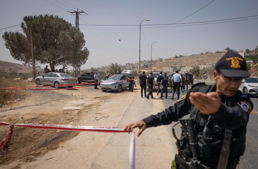  ISRAELI PERSONNEL secure the scene of Monday’s terrorist shooting attack on Highway 60, near Hebron. (photo credit: CHAIM GOLDBEG/FLASH90)