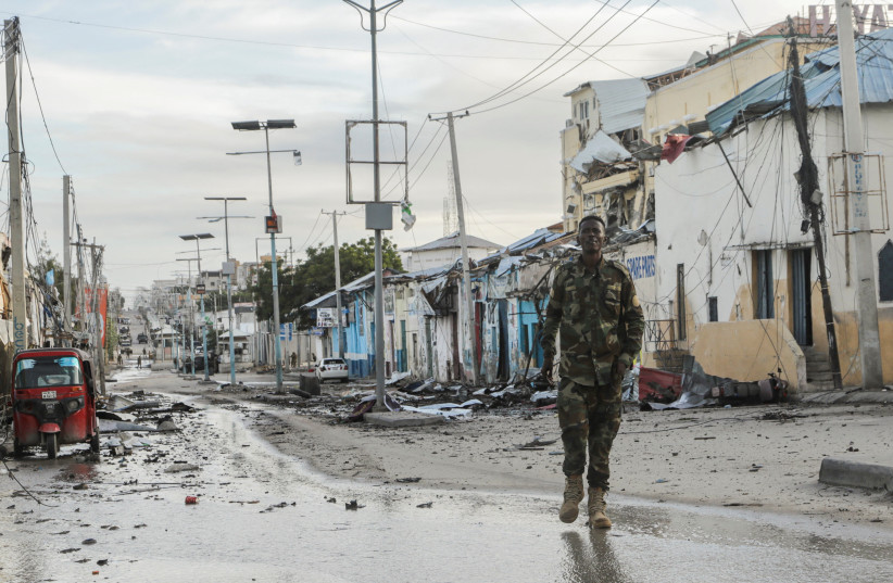  A Somali security officer walks past a section of Hotel Hayat, the scene of an al Qaeda-linked al Shabaab group militant attack in Mogadishu, Somalia August 20, 2022. (photo credit: REUTERS/FEISAL OMAR)