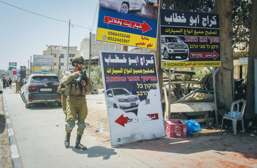  AN IDF soldier patrols last Sunday in Huwara where an Israeli father and son were gunned down by a terrorist the day before. The US doesn’t want to remind the public that Palestinian Arabs murder Jews at a car wash, argues the writer. (photo credit: NASSER ISHTAYEH/FLASH90)