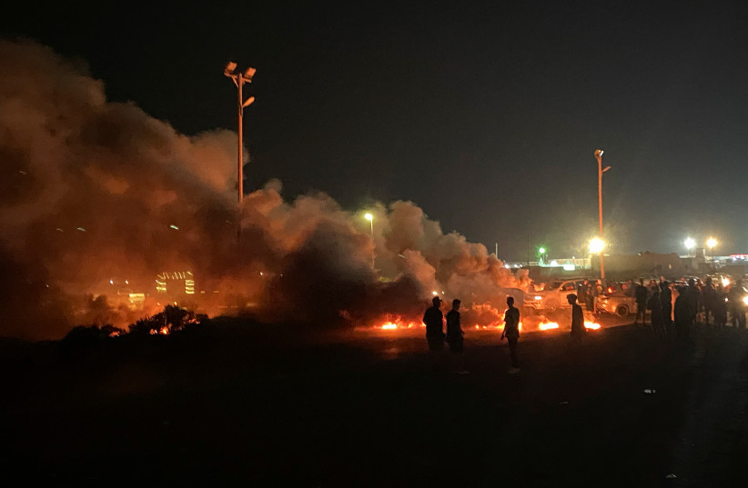 Demonstrators burn tires in protest against the meeting which was held last week in Italy between foreign affairs ministers of Libya and Israel, in Tripoli, Libya, August 27, 2023 (photo credit: REUTERS/Hani Amara)