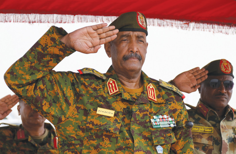  SUDAN’S GENERAL Abdel Fattah al-Burhan salutes for the national anthem after landing in the military airport of Port Sudan on Sunday, on his first trip away from Khartoum since the internal conflict broke out.  (photo credit: Ibrahim Mohammed Ishak/Reuters)