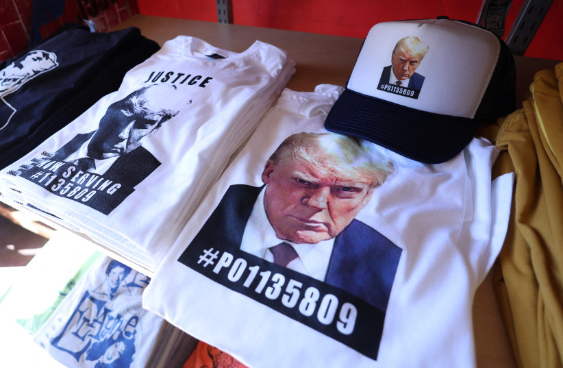  T-shirts and hats with an image depicting the mugshot of former U.S. President Donald Trump are pictured after being printed at the Y-Que printing store in Los Angeles, California, U.S., August 26, 2023. (photo credit: REUTERS/MARIO ANZUONI)
