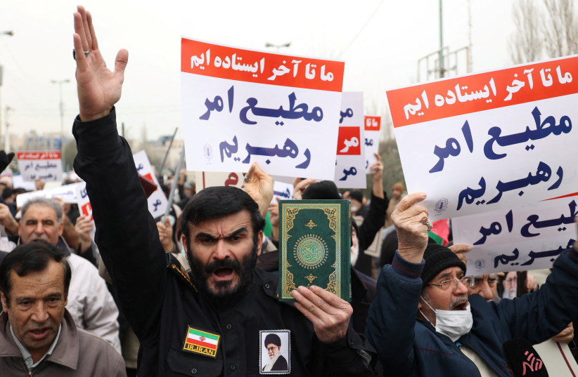  An Iranian protester holds the Quran in his hand during a protest to denounce the recent desecration of the Quran by far-right activists in Sweden, in Tehran, Iran, January 27, 2023.  (photo credit: Majid Asgaripour/WANA via Reuters)