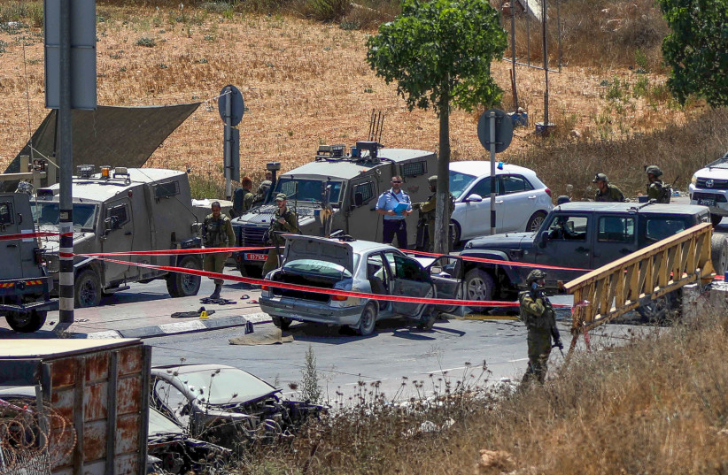  Police and rescue forces at the scene of a car ramming terror attack near Hebron, in the West Bank, August 30, 2023.  (photo credit: WISAM HASHLAMOUN/FLASH90)