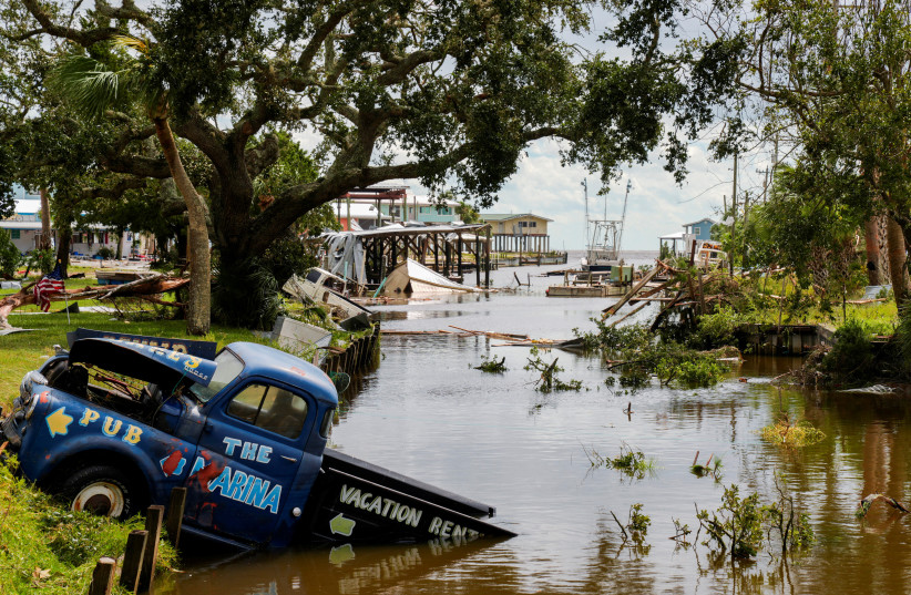  A view of a vehicle partially submerged in a canal after the arrival of Hurricane Idalia in Horseshoe Beach, Florida, U.S., August 30, 2023. (photo credit: REUTERS/Cheney Orr)