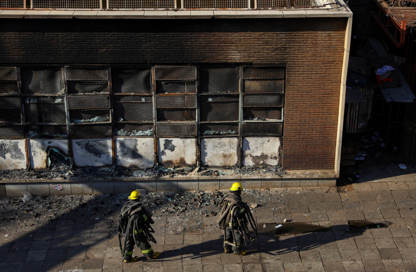  Firefighters walk at the scene of a deadly blaze, in Johannesburg, South Africa August 31, 2023. (photo credit: REUTERS/SIPHIWE SIBEKO)