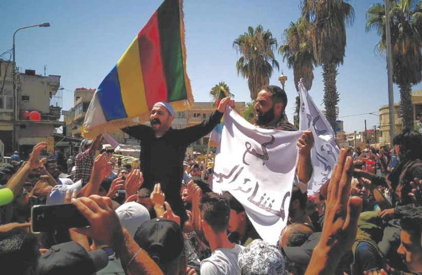  THE DRUZE flag is prominently displayed at a protest on August 24 in Syria’s Sweida province against the Syrian government’s decision to increase the price of fuel. (photo credit: Sweida 24/via Reuters)