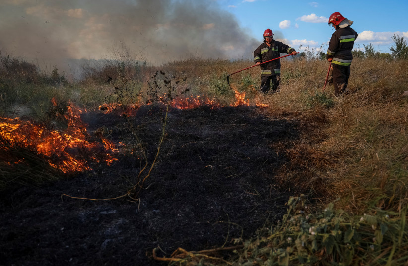 Ukrainian firefighters put out burning grass, amid Russia's attack on Ukraine, near a front line, in Zaporizhzhia region, Ukraine September 3, 2023. (photo credit: Oleksandr Ratushniak/Reuters)