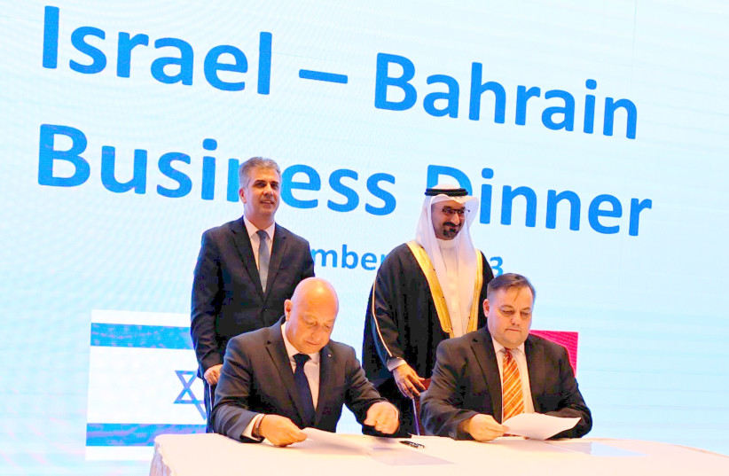  Trucknet CEO Hanan Friedman is seen signing a deal with a Bahraini company in the presence of Foreign Minister Eli Cohen and his Bahraini counterpart. (photo credit: Trucknet)