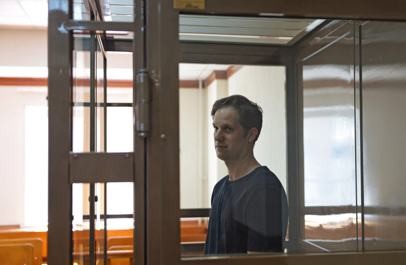  Wall Street Journal reporter Evan Gershkovich, who was arrested in March while on a reporting trip and accused of espionage, stands behind a glass wall of an enclosure for defendants before a court hearing to consider an appeal against his detention, in Moscow, Russia June 22, 2023. (photo credit: REUTERS/EVGENIA NOVOZHENINA)