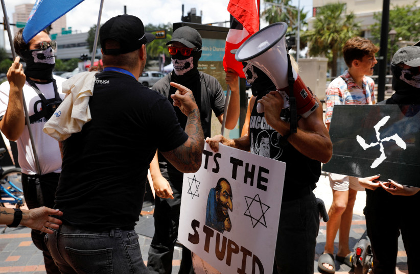  People wearing antisemitic and nazi symbols argue with conservatives during a protest outside the Tampa Convention Center where the Turning Point USA’s (TPUSA) Student Action Summit (SAS) is held, in Tampa, Florida, U.S. July 23, 2022.  (photo credit: REUTERS/MARCO BELLO)