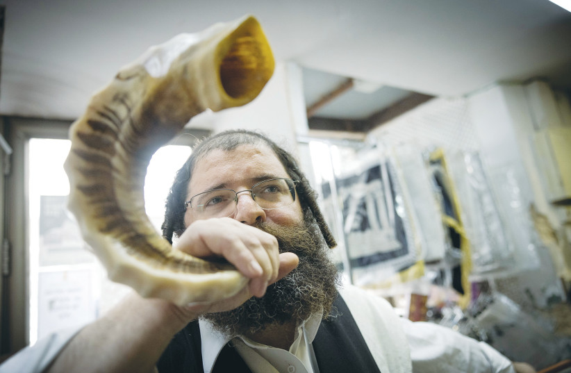  A MAN checks a shofar ahead of Rosh Hashanah. (photo credit: Chaim Goldberg/Flash90)