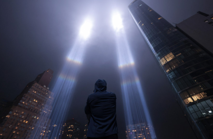 A person looks toward the Tribute in Light for the remembrance of the 21st anniversary of the September 11, 2001 attacks in Manhattan, New York City, U.S., September 11, 2022.  (photo credit: Andrew Kelly/Reuters)
