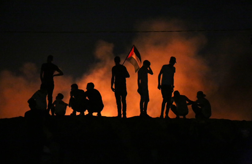 Palestinians protest at night time near the border with Israel, east of Khan Yunis in the southern Gaza Strip. September 2, 2021. (photo credit: ABED RAHIM KHATIB/FLASH90)