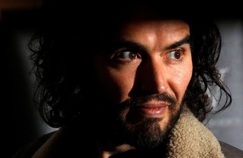 Comedian Russell Brand poses for photographers before signing copies of his new book entitled "Revolution" in central London, December 5, 2014. (photo credit: REUTERS/SUZANNE PLUNKETT)