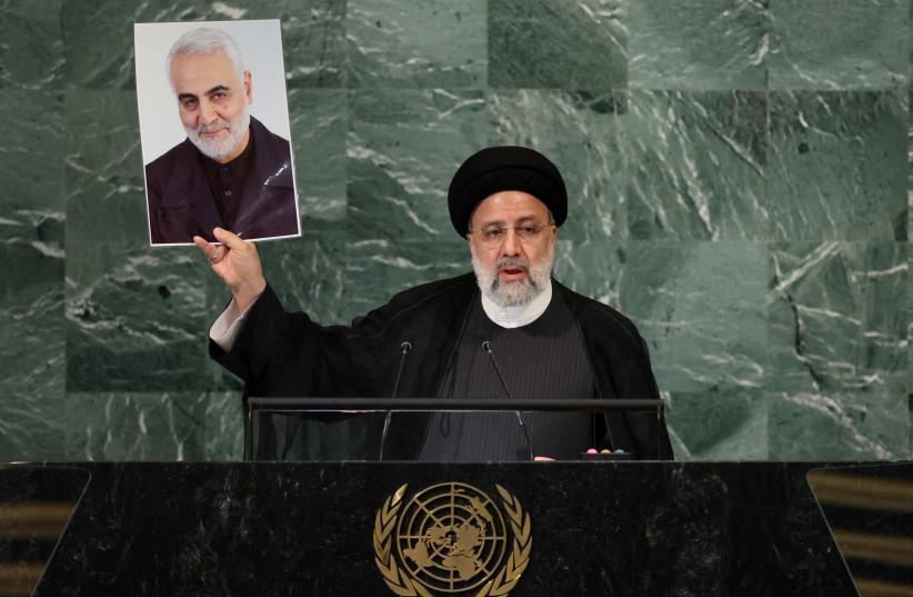 Iran's President Ebrahim Raisi holds up a picture of Quds Force Commander General Qassem Soleimani as he addresses the 77th Session of the United Nations General Assembly at UN Headquarters in New York City, US, September 21, 2022 (photo credit: REUTERS/BRENDAN MCDERMID)