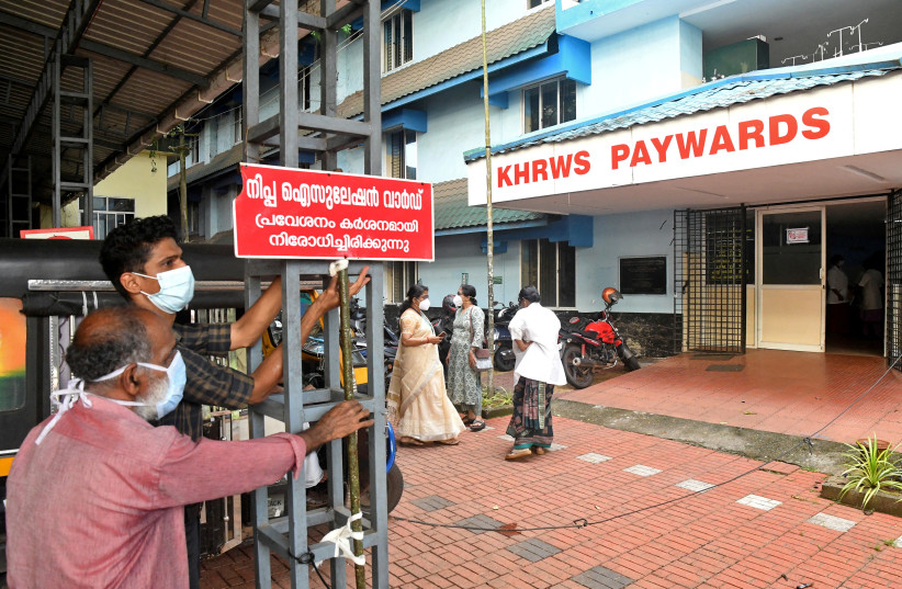 Staff members install a sign reading "Nipah isolation ward, entry strictly prohibited" at a hospital where a ward is being prepared for suspected Nipah virus patients in Kozhikode district, Kerala, India, September 12, 2023. (photo credit: STRINGER/ REUTERS)