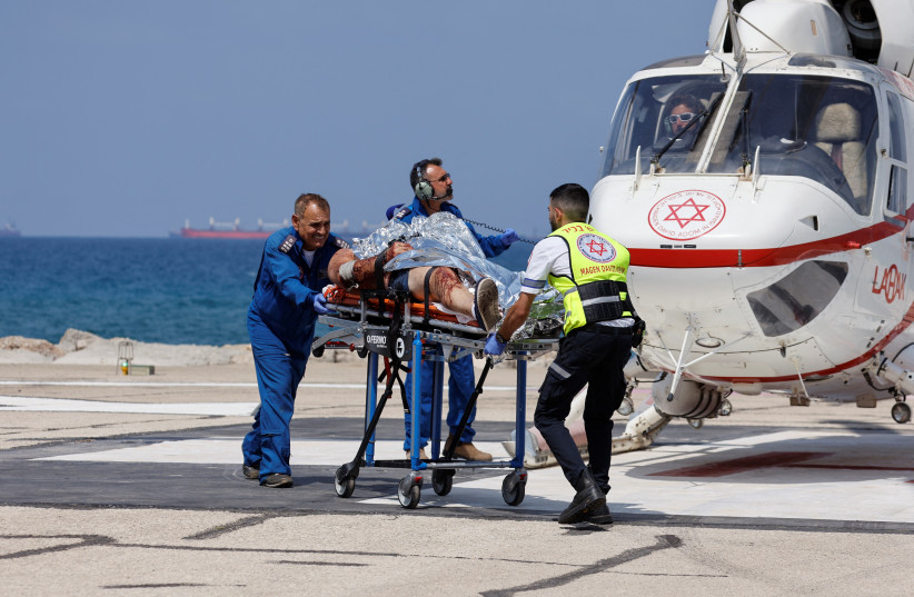  A wounded Israeli is taken off a helicopter as he arrives to Haifa hospital following a shooting attack in the Jordan Valley, in Haifa, Israel (photo credit: AMIR COHEN/REUTERS)