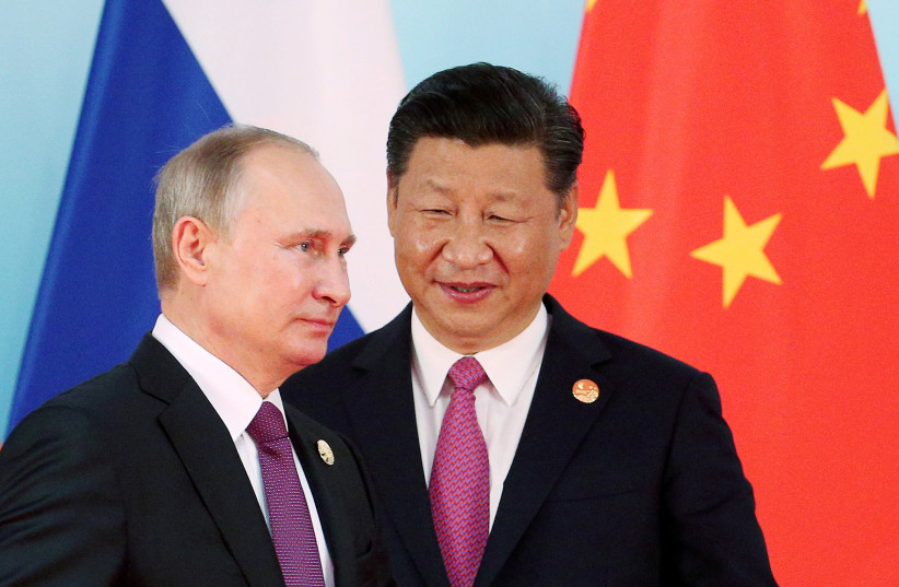  Chinese President Xi Jinping (R) stands next to Russian President Vladimir Putin as he arrives for a group photo during the BRICS Summit at the Xiamen International Conference and Exhibition Center in Xiamen, southeastern China's Fujian Province, China September 4, 2017 (photo credit: REUTERS/WU HONG/POOL/FILE PHOTO)