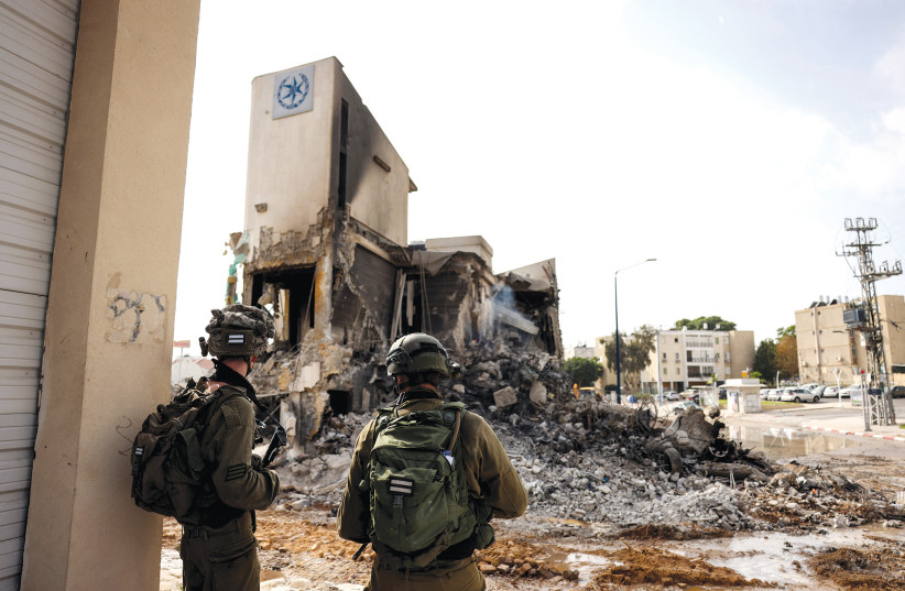 IDF soldiers inspect the remains of a police station in Sderot, which was the site of a battle following a mass infiltration by Hamas gunmen from the Gaza Strip, on October 8.  (photo credit: RONEN ZVULUN/REUTERS)