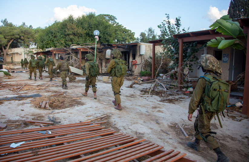 Soldații israelieni trec prin distrugerile provocate de militanții Hamas în Kibbutz Kfar Aza, lângă granița Israelo-Gaza, în sudul Israelului, 15 octombrie 2023. (credit foto: EDI ISRAEL/FLASH90)