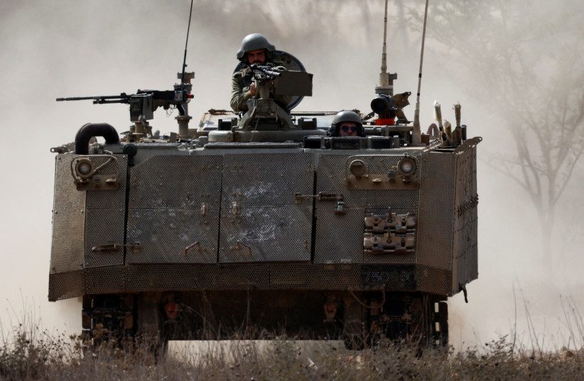  Israeli soldiers ride in an armoured personnel carrier (APC), amid the ongoing conflict between Israel and Hamas, near the border between Israel and Gaza Strip, in Israel, October 31, 2023. (photo credit: REUTERS/AMIR COHEN)