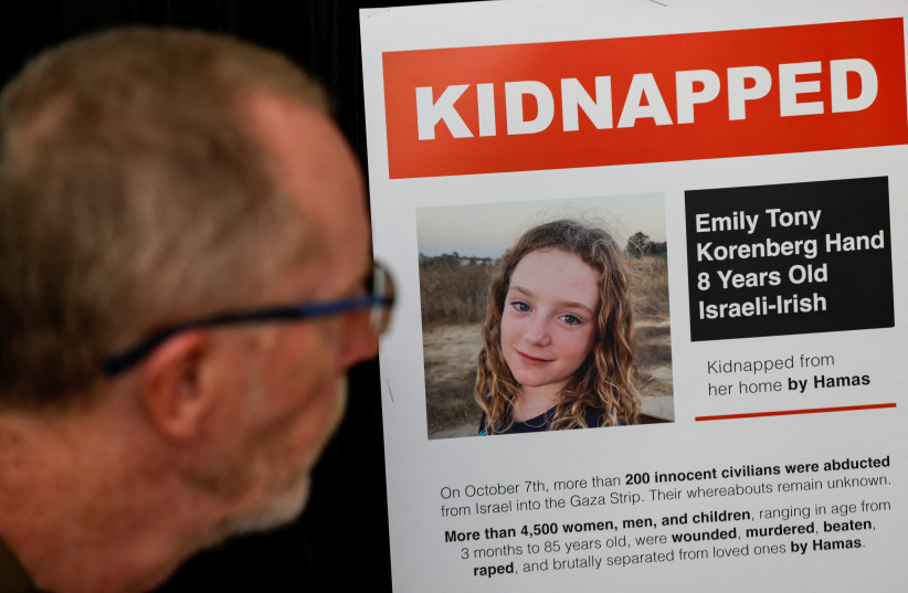 Thomas Hand, the father of Irish-Israeli Emily Hand, 8, who was announced dead following the October 7 attack on Israel by the Palestinian terrorist group Hamas, then later confirmed as one of the hostages held in the Gaza Strip, looks at a poster of Emily, November 10, 2023.  (photo credit: REUTERS/AMIR COHEN)