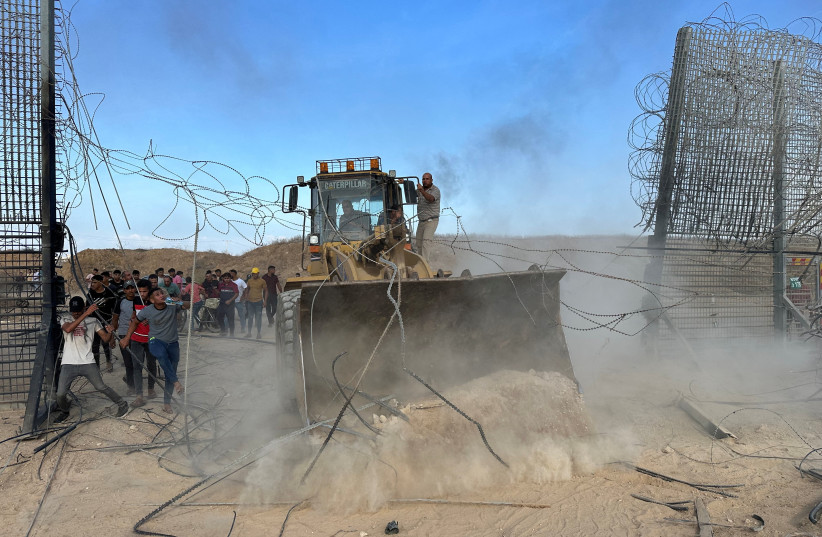 Los palestinos irrumpen en el lado israelí de la valla fronteriza entre Israel y Gaza después de que los terroristas de Hamás se infiltraran en zonas del sur de Israel, el 7 de octubre de 2023 (crédito de la foto: REUTERS/Mohammed Fayq Abu Mostafa).