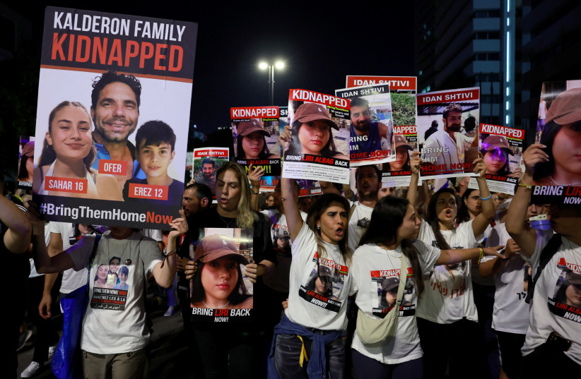 People carry placards during a protest calling for the immediate release of hostages held in Gaza who were seized from southern Israel on October 7 by Hamas terrorists during a deadly attack, at a square in Tel Aviv, Israel, November 11, 2023. (photo credit: REUTERS/AMMAR AWAD)