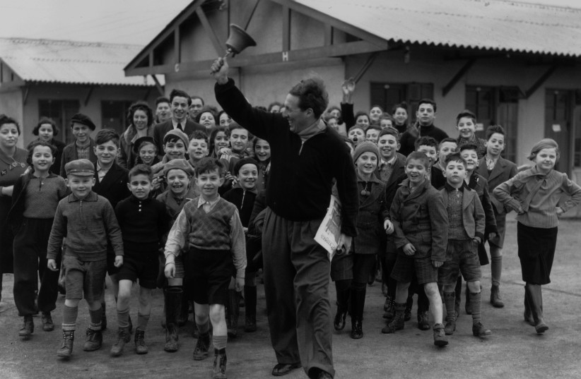  RINGING THE dinner bell at a camp for young Kindertransport refugees, at Dovercourt Bay near Harwich, 1939. (photo credit: Reg Speller/Fox Photos/Getty Images)