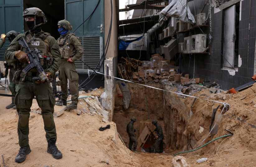 Israeli soldiers stand near the opening to a tunnel at Al Shifa Hospital compound in Gaza City, November 22, 2023 (photo credit: REUTERS/Ronen Zvulun)