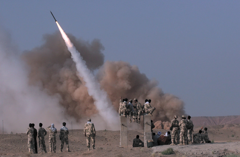 Members of Iran's revolutionary guard look at a surface to surface missile which is launched during a war game near the city of Qom, about 120 km (75 miles) south of Tehran June 28, 2011 (photo credit: RAUF MOHSENI/MEHR NEWS AGENCY/REUTERS)