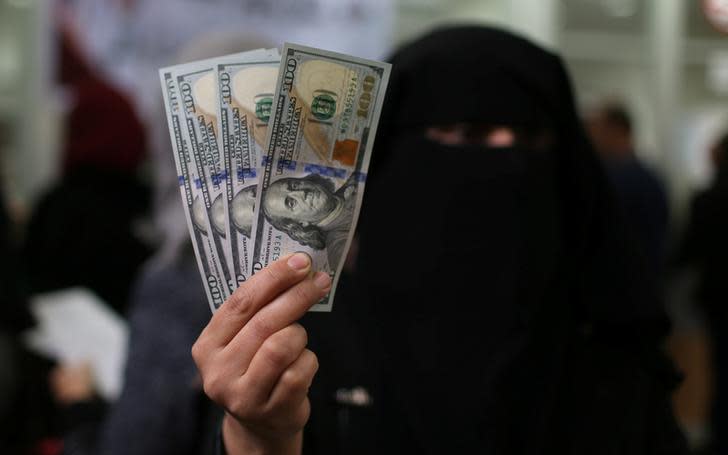 A Hamas-hired civil servant displays US Dollar banknotes after receiving her salary paid by Qatar, in Khan Yunis in the southern Gaza Strip, December 7, 2018; illustrative.
